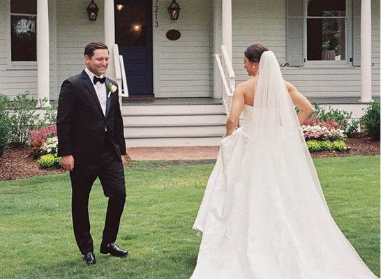 Bride and groom meeting outside a house